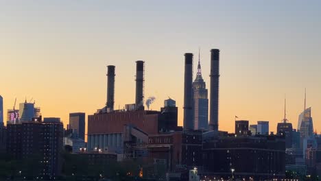 beautiful golden hour from an industrial site near the empire state seen from a boat crossing the hudson river in new york