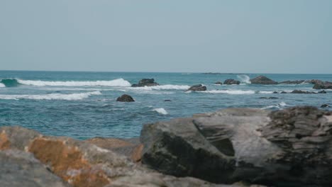 Olas-Salpicando-En-Las-Rocas-Junto-Al-Océano-Azul-Durante-El-Verano-En-Weligama,-Matara,-Sri-Lanka