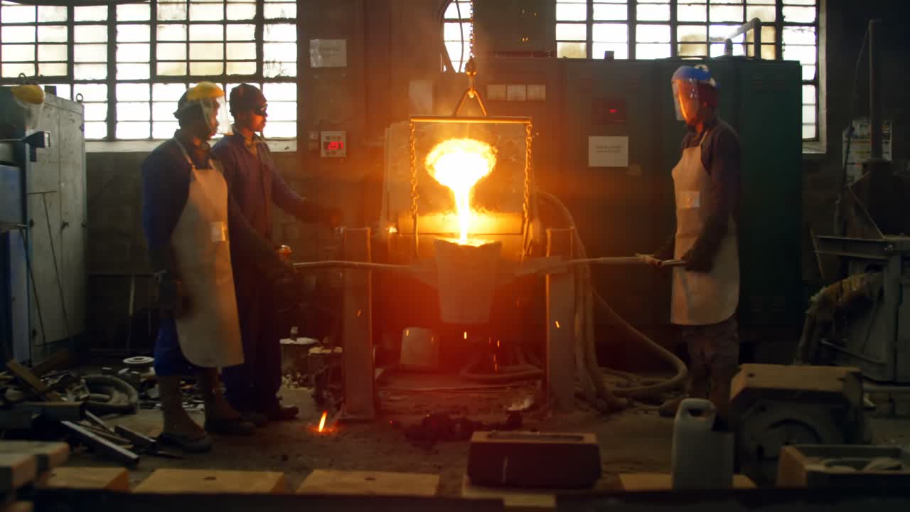 trabajadores que funden metal en el taller de fundición 4k