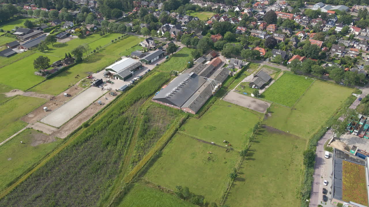 시골 마을 가장자리에 있는 큰 농장 건물을 향해 날아갑니다