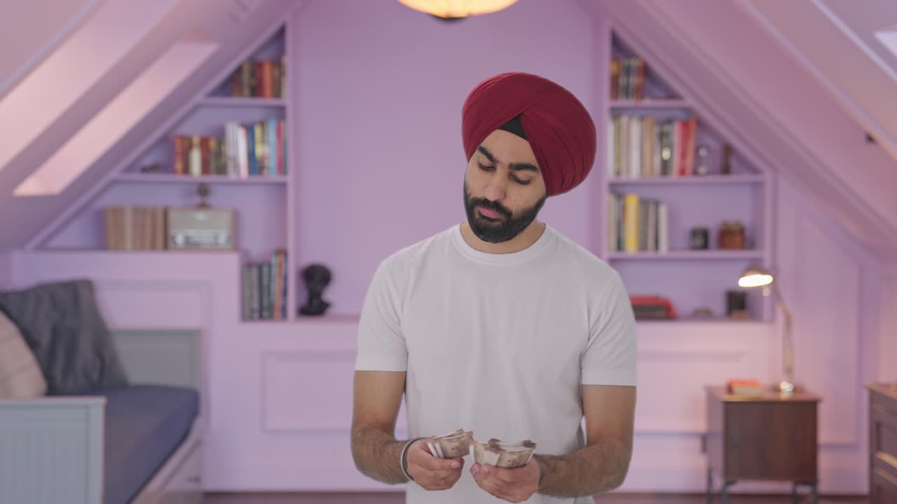 Uomo indiano Sikh triste che conta denaro