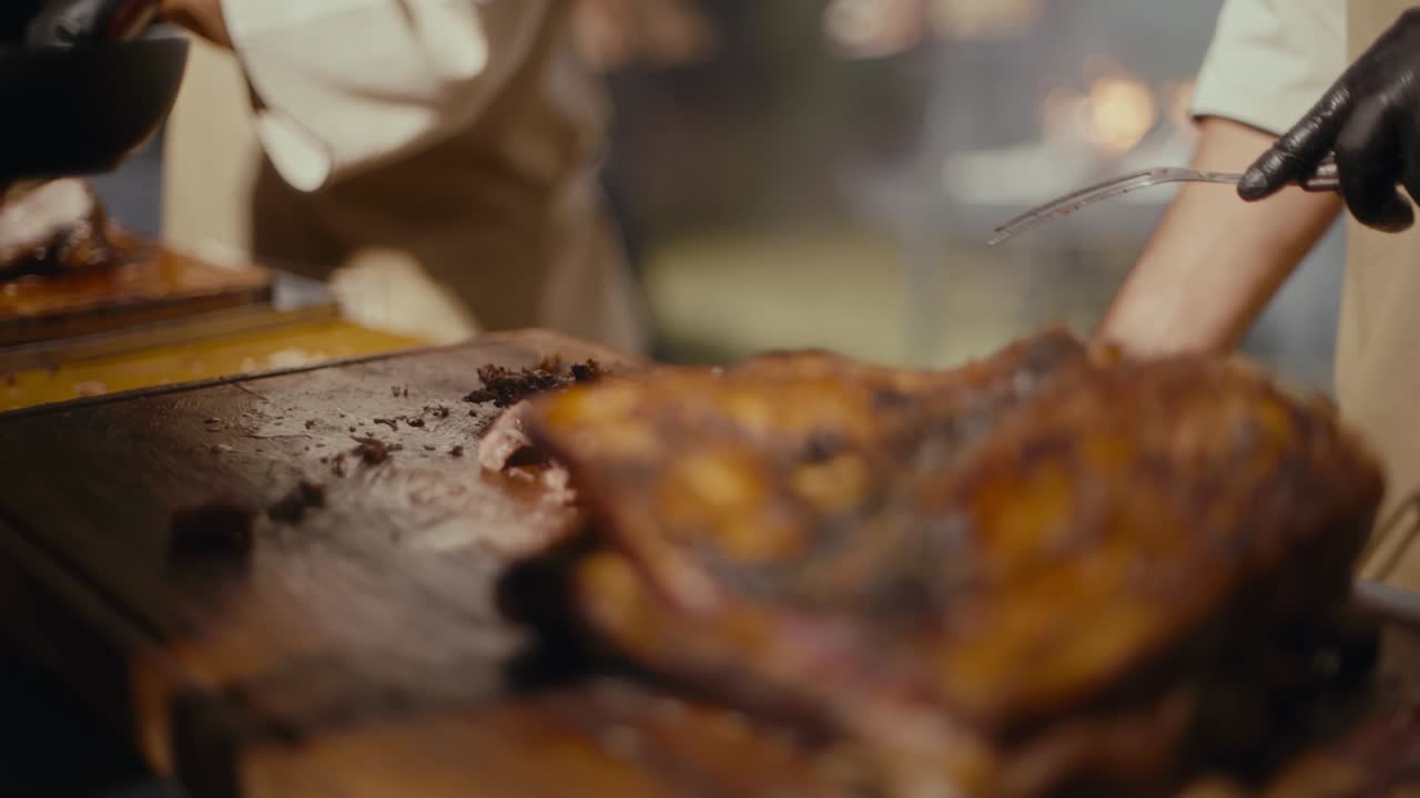 Chef expertly cuts golden-brown roasted meat. Hands in black gloves show precision and care. Focus remains on the rich, seasoned roast. Ideal for culinary, food, or restaurant content