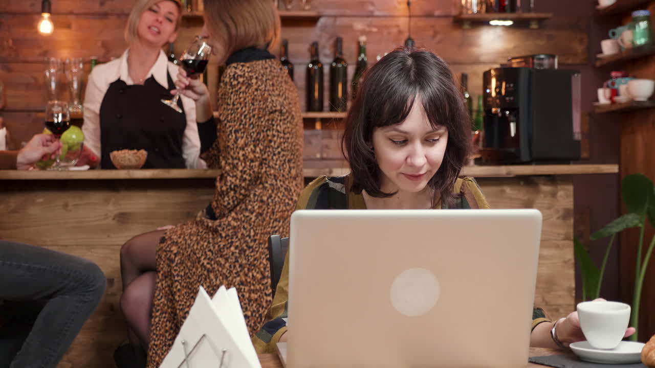 mujer trabajando en una computadora portátil en un café