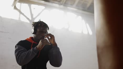 Low-Angle-Footage-Young-Male-Boxer-Practicing-Shadow-Boxing-In-Headphones