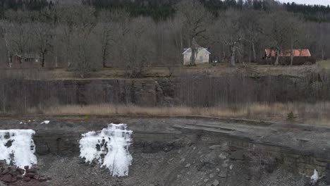 Aerial view sideways drone flight winter landscape over lake in Kinnekulle Sweden