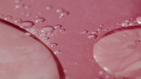 red liquid surface with bubbles of oil floating atop
