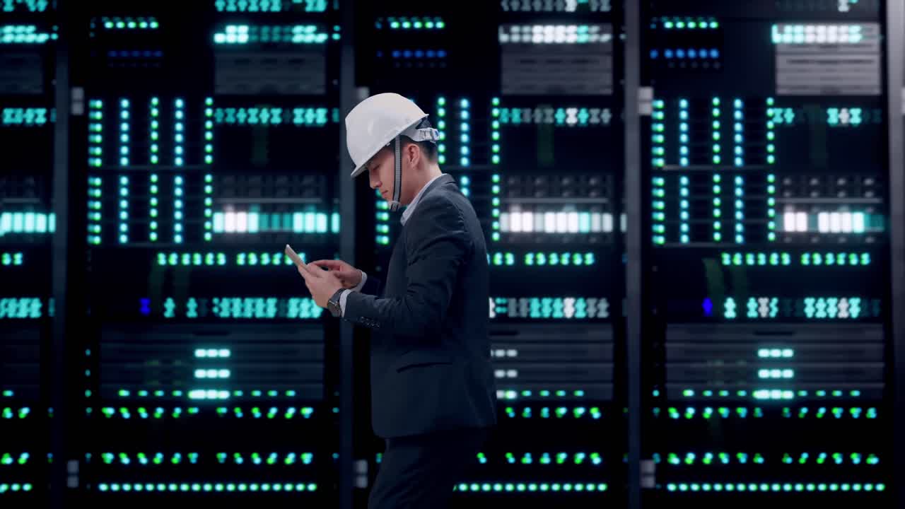 Side View of Asian Businessman Use Tablet While Walking in Server Room Data Center
