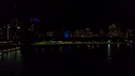 vista aérea de izquierda a derecha de la costa a lo largo de honolulu hawai por la noche