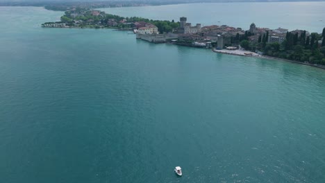 distant aerial capturing deep blue lake meeting the castle coastline