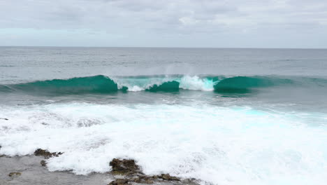 new wave emerging during cyan tide approaching the coastline captured by wide angle 4k slow motion capture at 60fps