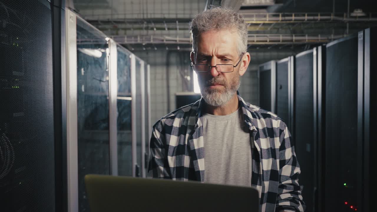 Technician Working on Laptop in Server Room