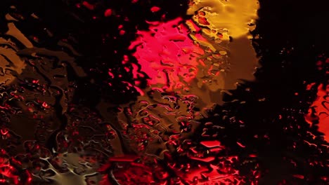 luces de noche lluviosa reflejadas a través de la ventana