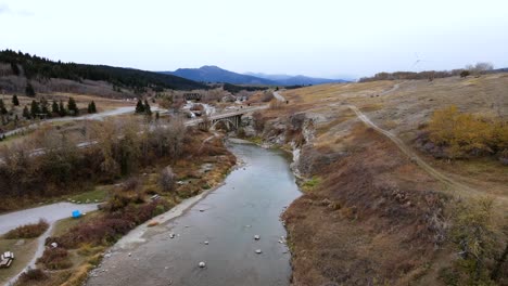 slow motion aerial footage of drone approaching a concrete truss bridge way down below