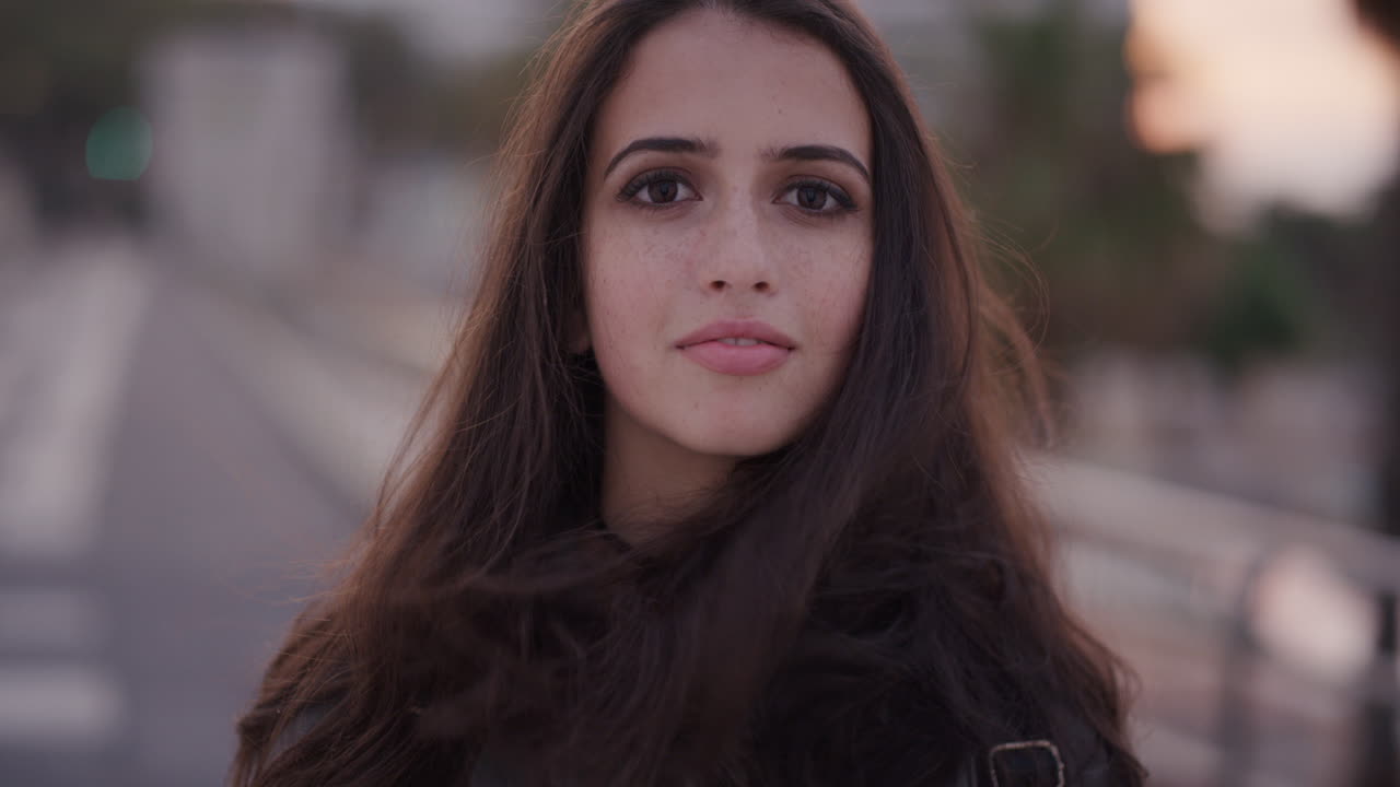 retrato hermosa joven adolescente sonriendo corriendo mano a través del cabello disfrutando de la brisa soplando en cámara lenta