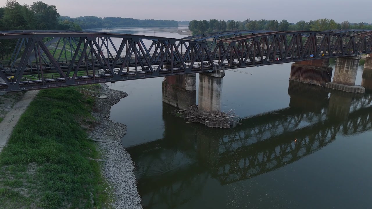 Cremona Iron Railway Bridge spans the Po River in Cremona, Lombardy, Italy, with exposed gravel banks revealing low water level during the 2026 heatwave, static.
