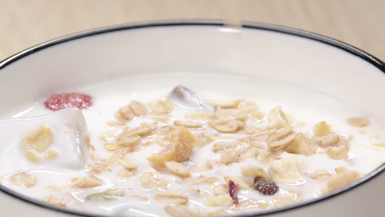 Una rinfrescante scena di colazione per uno stile di vita sano con l'aggiunta di mandorle tritate o scaglie di cocco a colorati cereali mattutini a forma di stella, accompagnati da yogurt naturale con semi di zucca, un prodotto lattiero-caseario