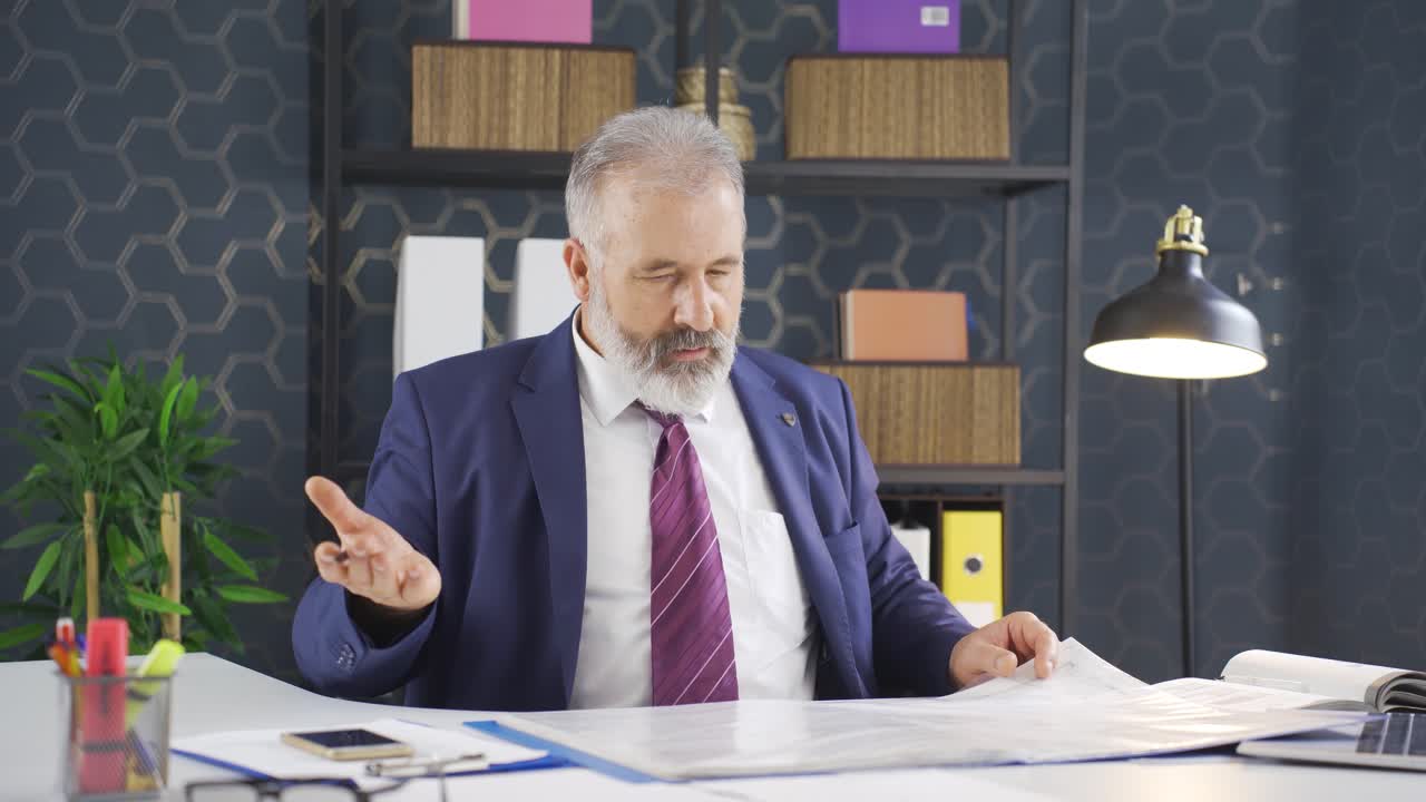 un hombre de negocios enfurecido cierra los archivos de papeleo.
