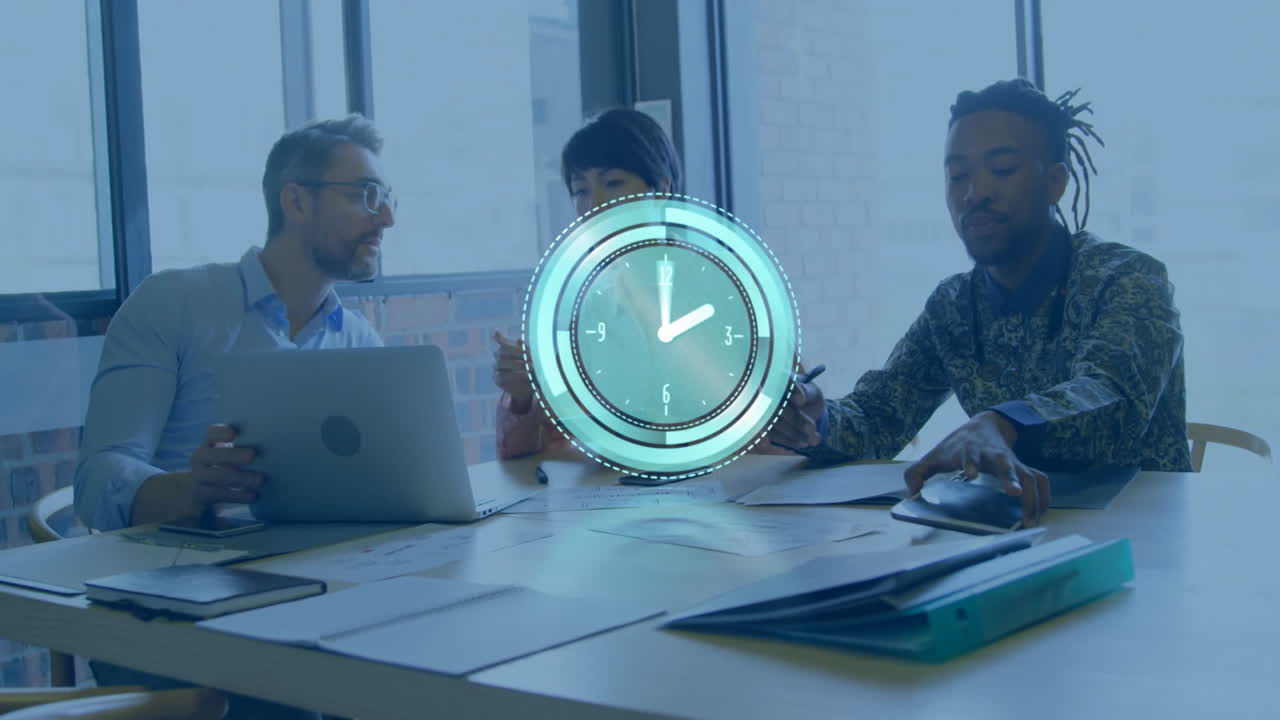 Clock animation over diverse business team working at table with laptops