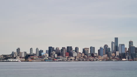 transbordadores y barcos en la bahía de elliott con el horizonte de seattle, washington en el fondo - lapso de tiempo panorámico
