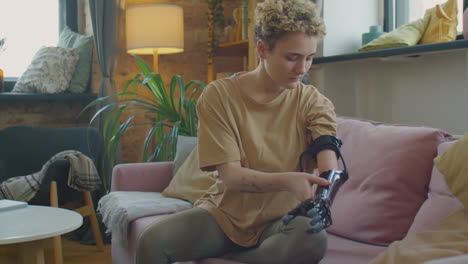 girl putting on prosthetic arm at home