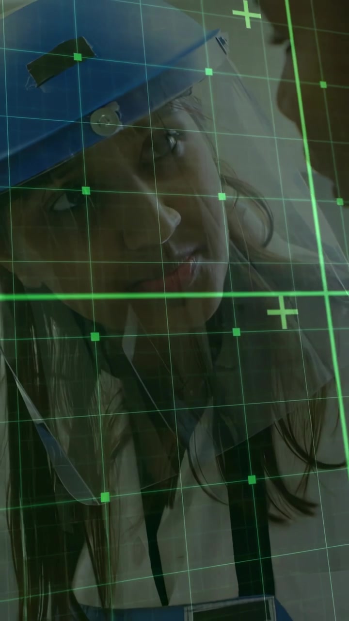 Video verticale: Donna con cappellino blu che si china verso un uomo, con una griglia verde che sale, allineando i volti in una clinica.