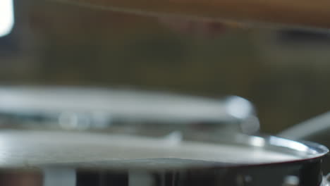 a close-up, blurry shot of a drumstick resting on a drum
