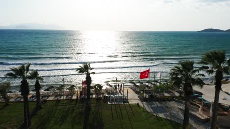 turkish flag is waving in wind on sandy beach, famous tourist destination in kusadasi