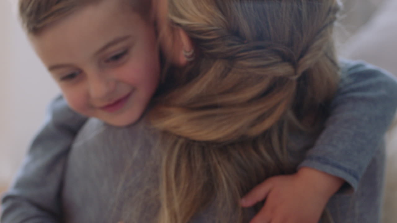 счастливый мальчик обнимает мать улыбается обнимает сына наслаждается материнской любовью милый ребенок обнимает маму показывает привязанность дома семейная концепция 4k кадры