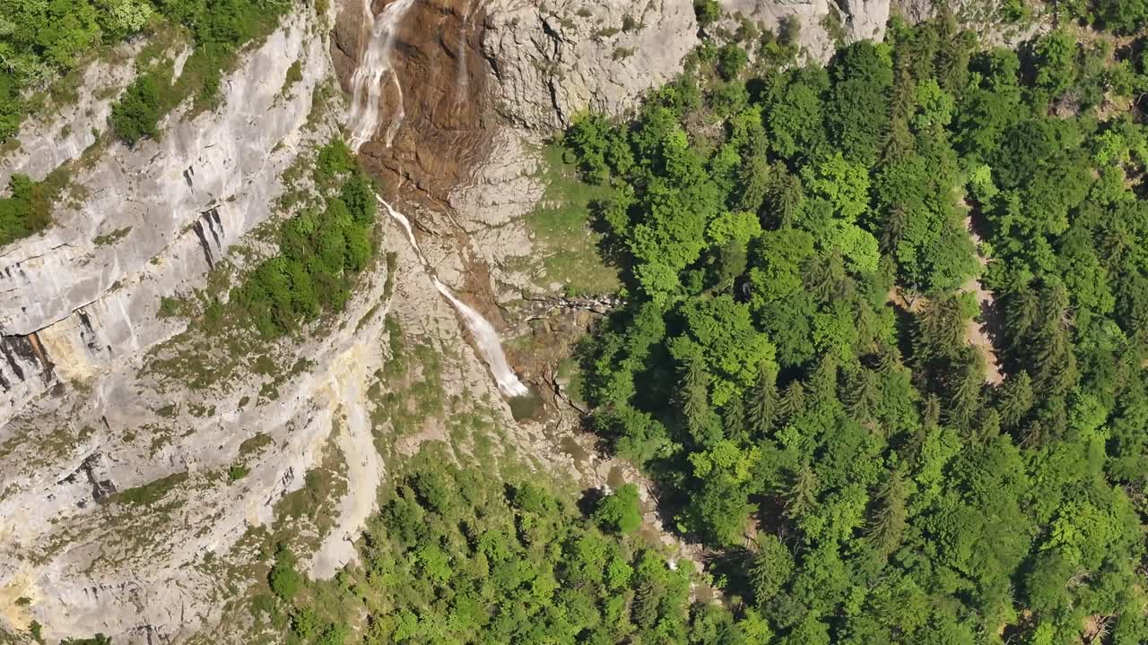Seerenbach Falls plunges down steep alpine cliffs in Switzerland, surrounded by lush forest and dramatic rocks, a striking display of natural vertical beauty