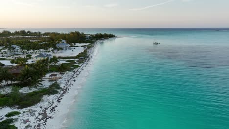 Bahamas-Sunset,-White-Sands,-Aqua-Water,-and-Sailboat,-Aerial-Beach-View