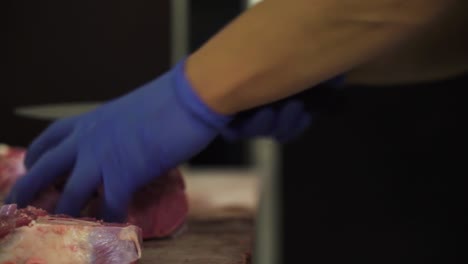 local butcher preparing meat for cooking with sharp knife