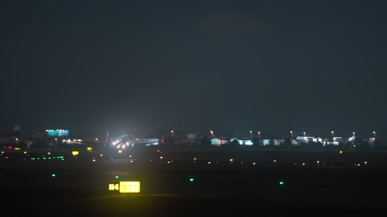 夜の空港滑走路から離陸する旅客機