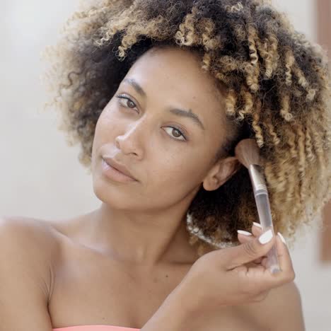 mujer joven poniéndose maquillaje
