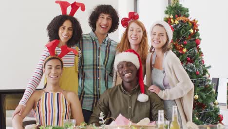 portrait of happy group of diverse friends sitting at table and eating dinner together