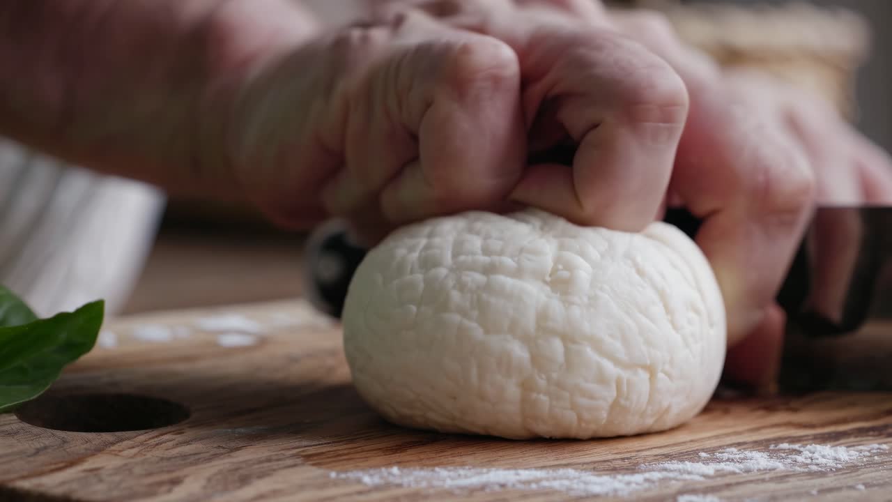 Primo piano di un video di una forma rotonda di formaggio su un tagliere di legno, che cattura la consistenza e la freschezza