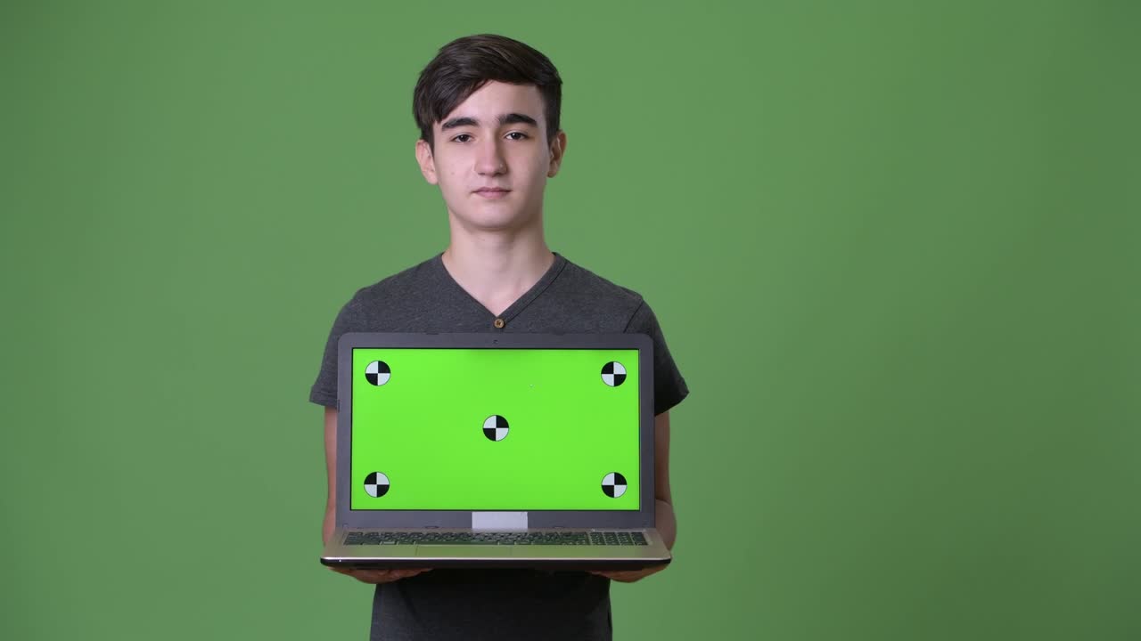 초록색 배경에 젊은 잘생긴 이란 십대 소년