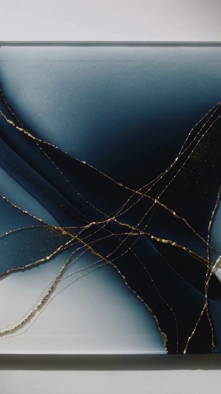Video verticale: Telecamera in movimento che si sposta su una parete bianca per mostrare arte blu, una sporgenza e venature dorate.