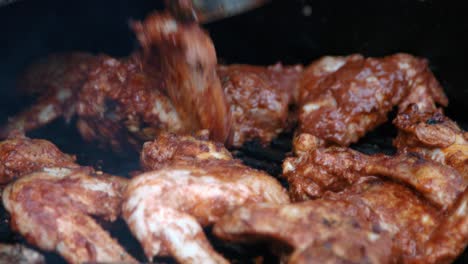 bbq chef turning chicken wings on smokey bbq