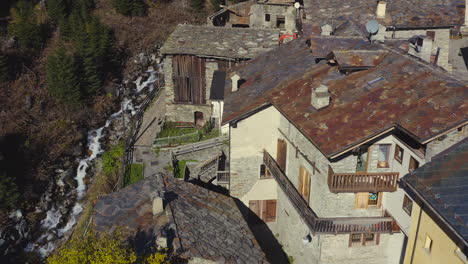 a view of an old village roof tops in the mountains with river streaming