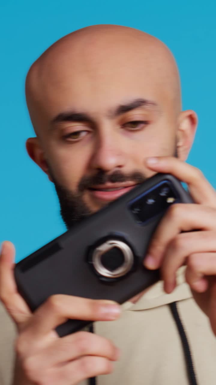 Video verticale: ragazzo mediorientale si diverte a un contest di videogiochi davanti alla telecamera