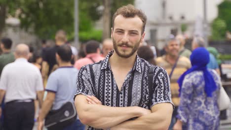 young man with crossed arms looking at camera.