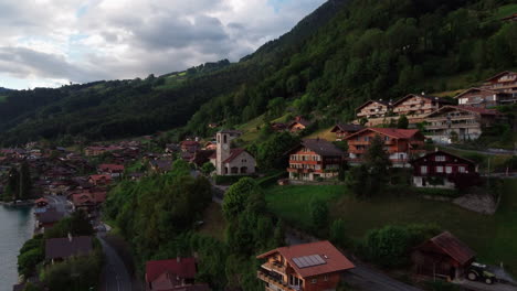 aerial tour of merligen on lake thun, thunersee flying past the traditional stone chapel