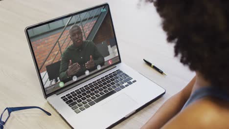 mujer de negocios afroamericana usando una computadora portátil para una videollamada con un colega de negocios afroamericano
