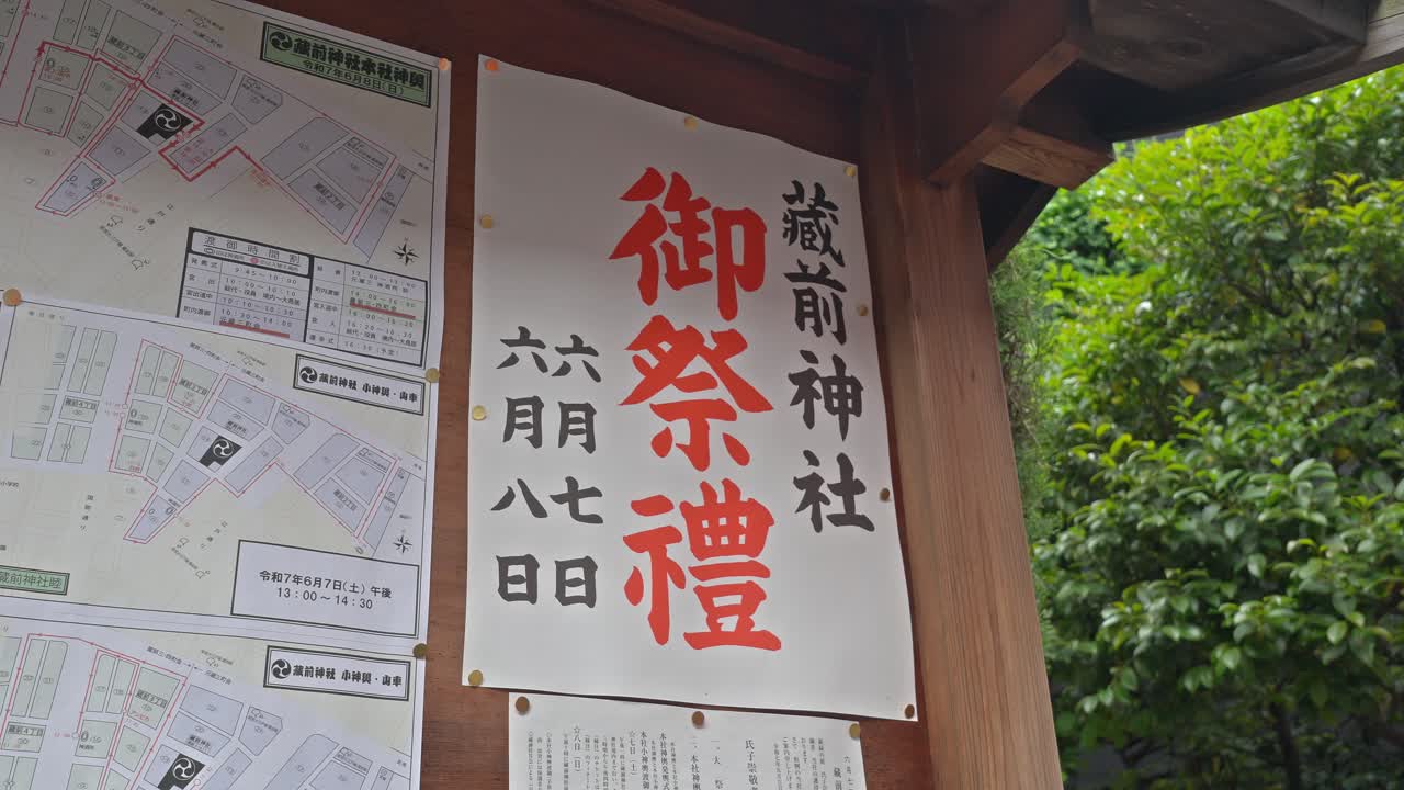 An information board at Kuramae Shrine displays details for an upcoming festival, with bold Japanese calligraphy and a map.