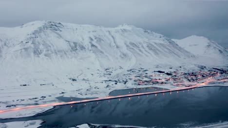 aerial panning shot of avalanche protection and snow fences in snowy mountains above siglufjordur city in iceland