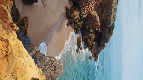 Playa-Praia-De-Almograve-Con-Olas-Del-Mar,-Acantilados-Y-Piedras,-Arena-Dorada-Húmeda-Y-Vegetación-Verde-En-La-Costa-Salvaje-De-Rota-Vicentina,-Odemira,-Portugal