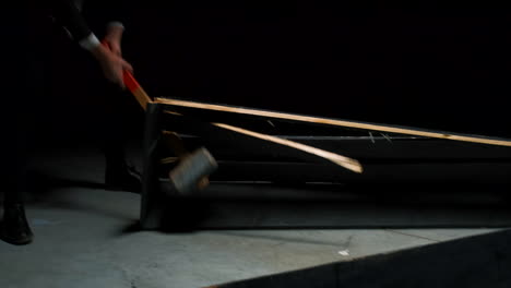 businessman destroying wooden planks with a hammer