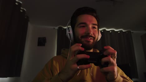 Male-gaming-with-a-game-pad-smiling-and-laughing