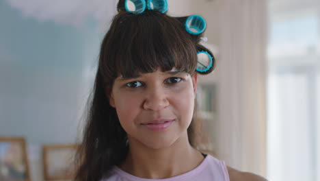 portrait funny teenage girl wearing hair curlers looking awkward teenager at home teen self image concept 4k footage