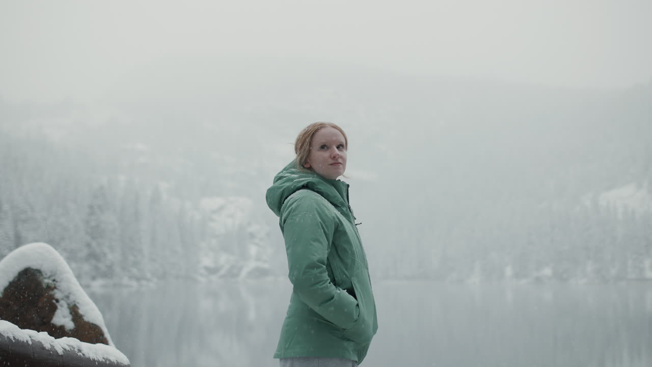 Woman enjoying a snowy landscape by a lake